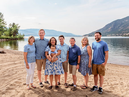 Extended family standing on Summerland beach posing for the camera at baby's first birthday