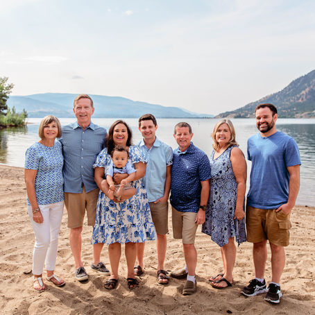 Extended family standing on Summerland beach posing for the camera at baby's first birthday