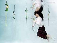 ritratto fotografico di donna immersa nell'acqua con fiori in mano