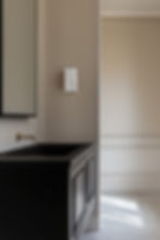 Alabaster wall-mounted light above dark vanity