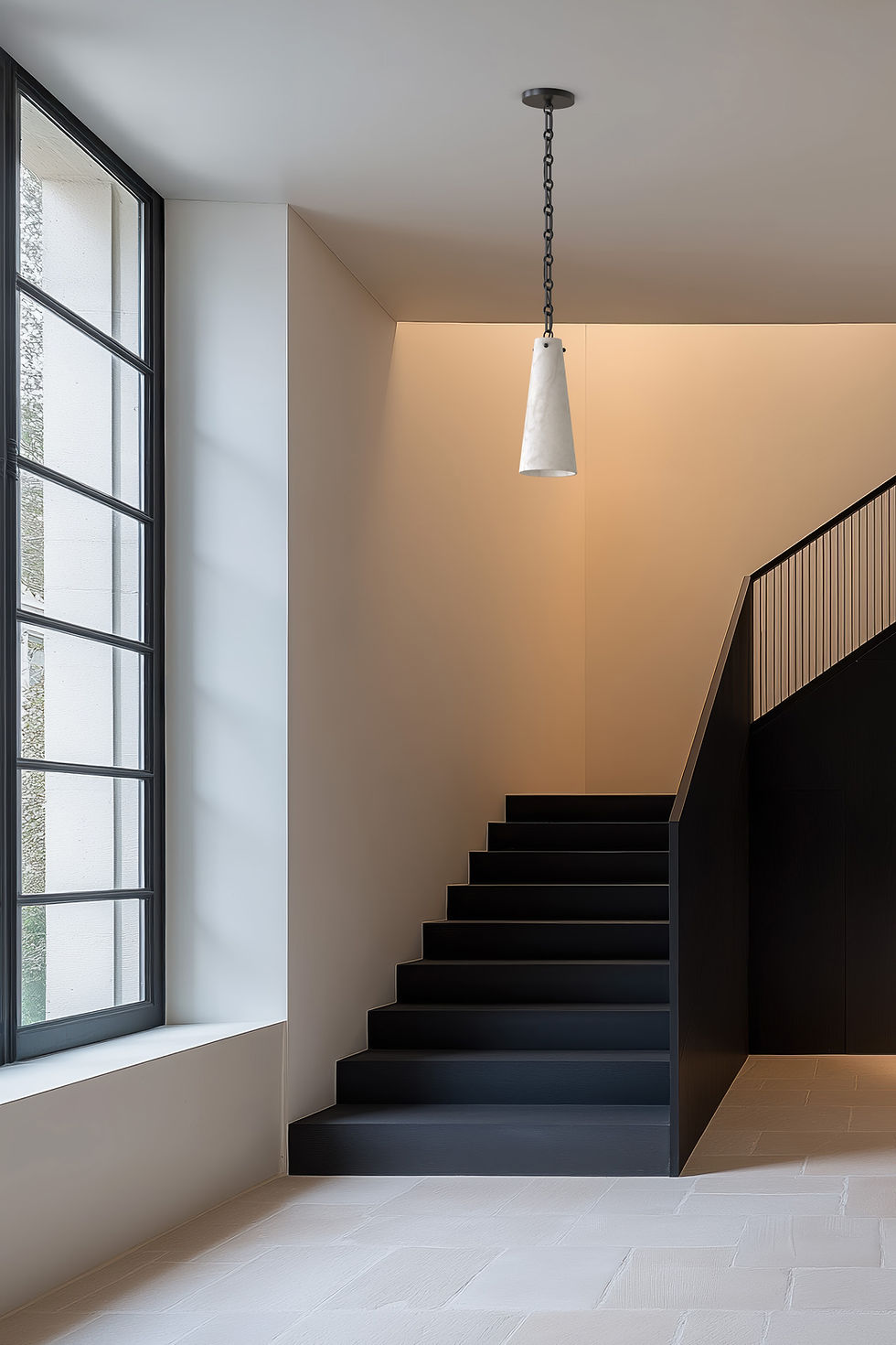 Alabaster pendant light hangs above a modern staircase