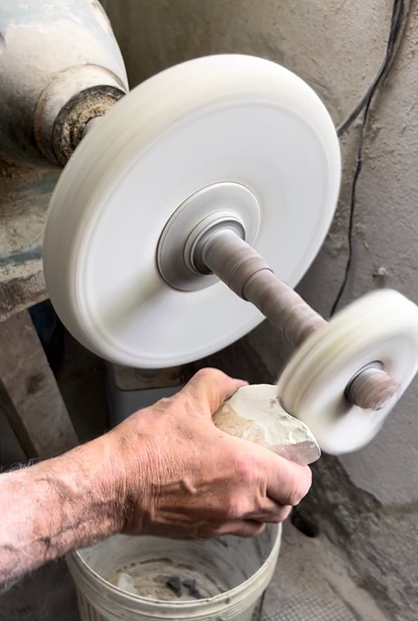 An artisan polishing a piece of alabaster.