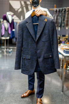 Dapper Professional holding a custom camo blazer in Provenance