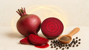 Whole and sliced beets with a wooden spoon of spices on a light background. Black peppercorns and soft glowing lines add visual interest.