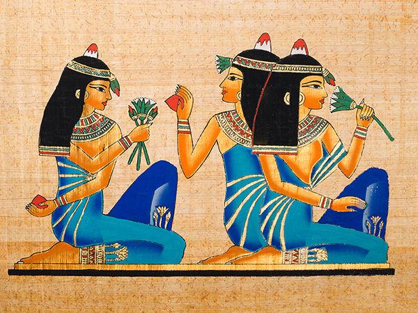 Ancient Egyptian painting of three women holding lotus flowers, wearing traditional blue dresses; the lotus represents rebirth, eternity, and divine beauty in Egyptian art and history.