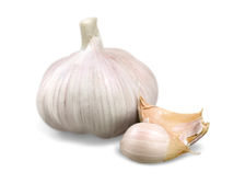 A whole garlic bulb with a pale, papery skin and a few separated cloves, one of which is partially peeled to reveal its creamy white interior. Source: Canva.