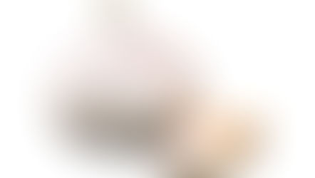 A whole garlic bulb with a pale, papery skin and a few separated cloves, one of which is partially peeled to reveal its creamy white interior. Source: Canva.