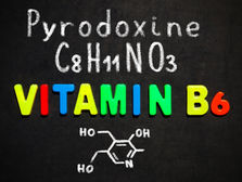 Colorful letters spell "VITAMIN B6" on blackboard, with "Pyrodoxine," "C8H11NO3," and chemical structure drawn in white chalk above.