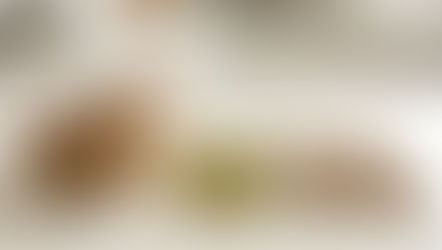 Cardamom powder in a small bowl beside clear capsules and green cardamom pods on a clean kitchen counter.