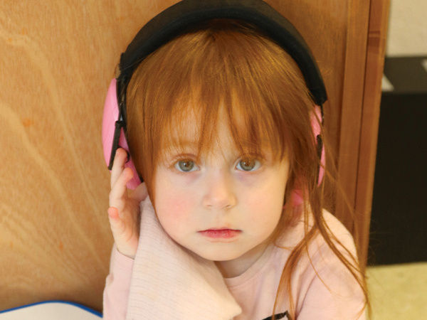 Adelen shown at school wearing headphones