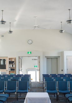 Blue chairs facing a podium in an auditorium, Visit Us at Ottawa Gospel Hall