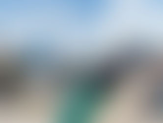 Comparison between air and sea freight transportation: a cargo airplane being loaded with pallets, and a container ship docked at a port full of containers.