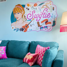 Music-themed Airbnb living space in North Nashville featuring teal sofa, pink accents, and custom wall art