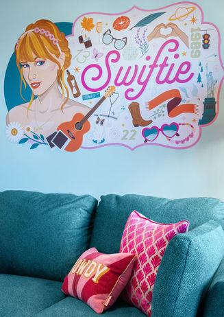 Music-themed Airbnb living space in North Nashville featuring teal sofa, pink accents, and custom wall art