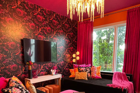 Lyric Lounge Nashville bachelorette Airbnb featuring bold red floral walls, velvet seating, and glam lounge design
