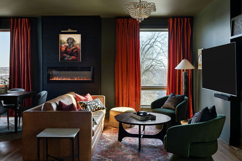 Moody Melrose premium short term rental living room on 8th Avenue in Nashville featuring fireplace, rich textures, and dramatic drapery