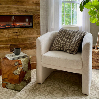Cozy reading nook design for a Nashville short term rental with accent chair, textured pillow, and warm wood tones