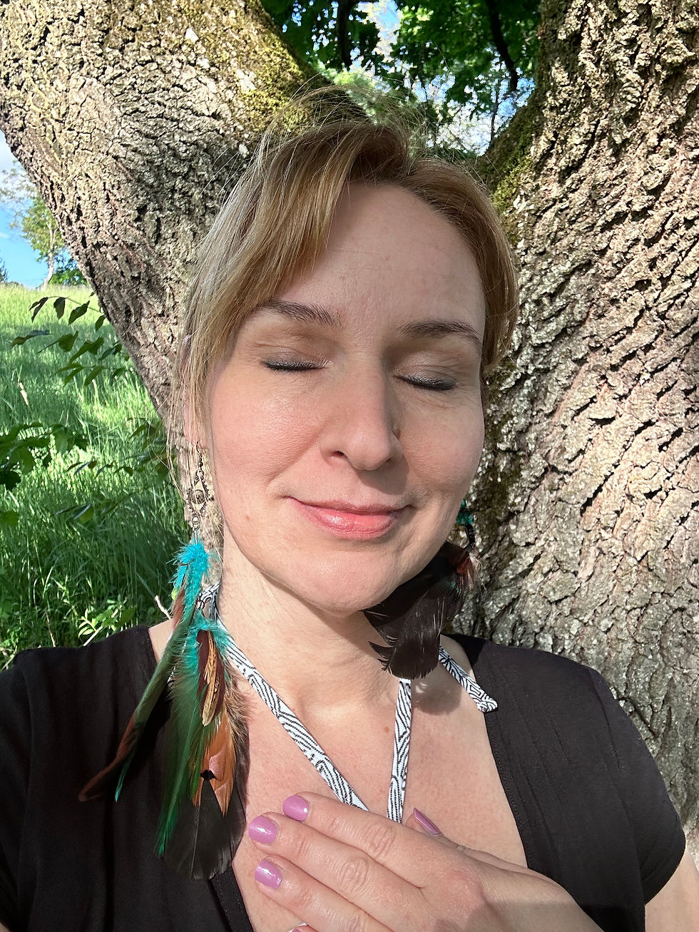 Frau mit geschlossenen Augen an einem Baum lehnend