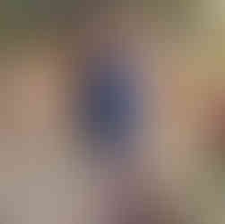 Frauenkreis in bunten Kleidern legt die Hände gemeinsam über einen Ritualplatz mit Blüten, Kräutern