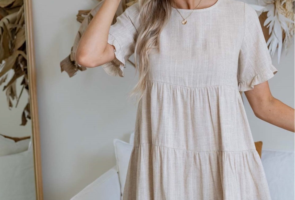 Stone coloured linen mini dress, smock style Smock style Easy fit Wooden buttons at back 3/4 Sleeve with frill Pannel detail