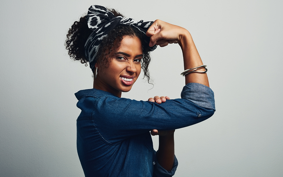 A woman with a bandana on her head holding her right arm as a sign of empowerment