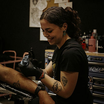 Shawna tattooing a customer.