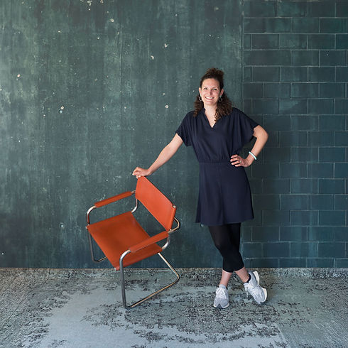 Nicole Gätzi von ELOCIN LIVING hält einen Secondhand Freischwingerstuhl in der Hand, Symbol für nachhaltige und individuelle Einrichtung.
