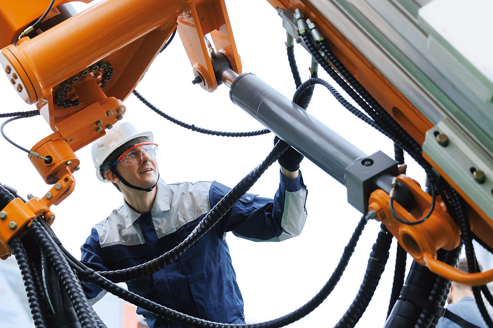 Male engineer inspecting hydraulic hoses of heavy machinery in mining industry.jpg