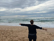 Claire practising winter Qigong on Manly Beach, connecting with the ocean, sky and seasonal energy.