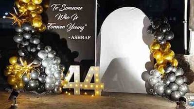 Elegant black and gold birthday balloon decoration with illuminated number backdrop and party setup in Kolkata.