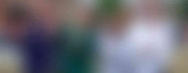 A group posing with painted pumpkins.