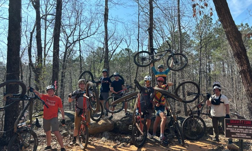 A group posing with their mountain bikes