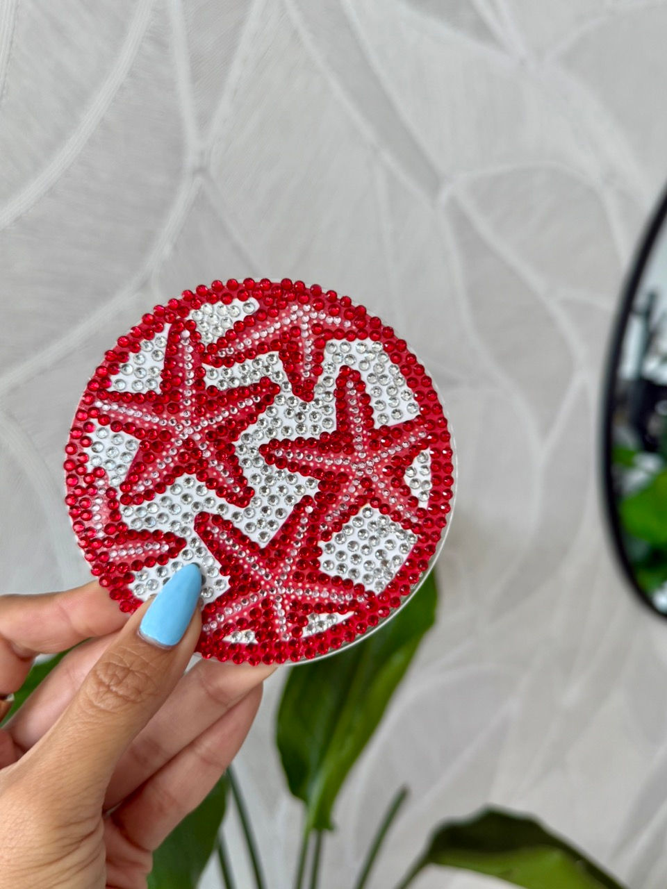 Thumbnail: A handcrafted rhinestone coaster with a red starfish design, displayed on a wooden tray with a cork backing
