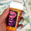 Thumbnail: BURN Bedazzled Pill Bottle with pink strong woman design, featuring pink and purple lips adorned with rhinestones. fat burnin
