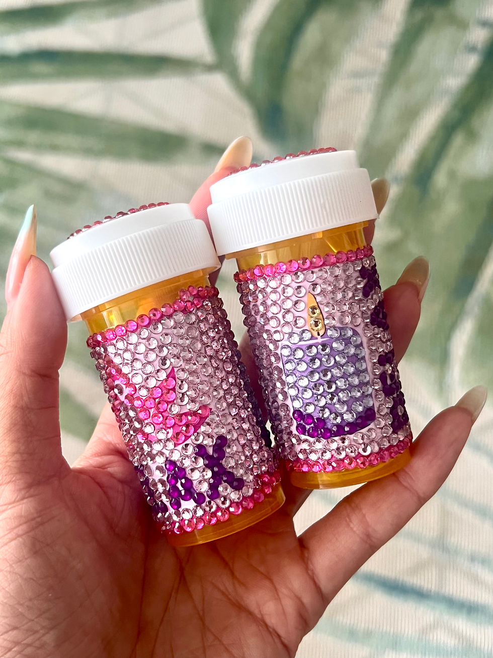 Thumbnail: pink pill bottle with a yogi, pink lotus, and purple rhinestones spelling "Relax", alongside a lavender candle design. bedazz