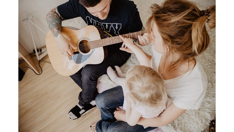 Parents singing and playing guitar for baby