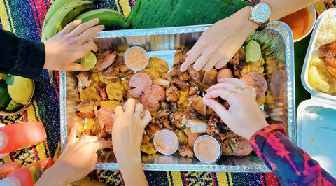 Mangú Delight food platter on a table with people sharing it