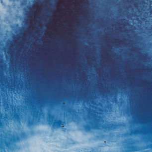 The cover art for Australian ambient electronic producer Floating Shrine's Connecting album, showing birds flying in a bright blue sky with wispy, textured clouds. The scene evokes a sense of freedom and tranquility.