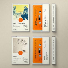The cassette tapes for Vieux & Cheick Niang/Guguou - Brothers albums; top shows musicians Vieux & Cheick Niang, bottom shows abstract art. Bright orange cassettes, beige background.