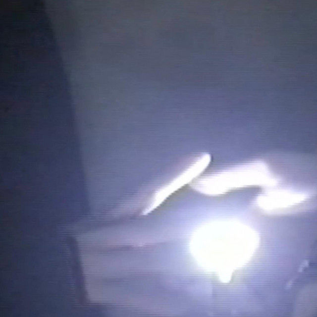 The cover for Casha Mour's, AAOO album of lo fi electronica. It shows hands holding a glowing light in a dark setting, creating a mysterious and late night atmosphere.
