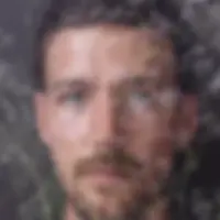 John Hanson, aka Saltbreaker's fac, overlaid with delicate white baby's breath flowers. The background is dark, creating a serene and contemplative mood.