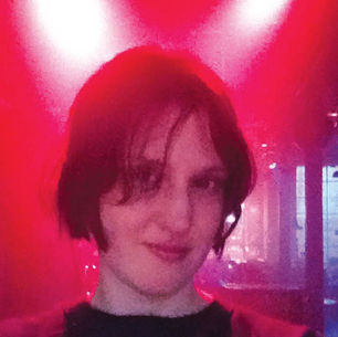 The cover for Joanne Robertson's Blurrr album, showing Robertson with short dark hair smiling in a dimly lit room with red lighting.