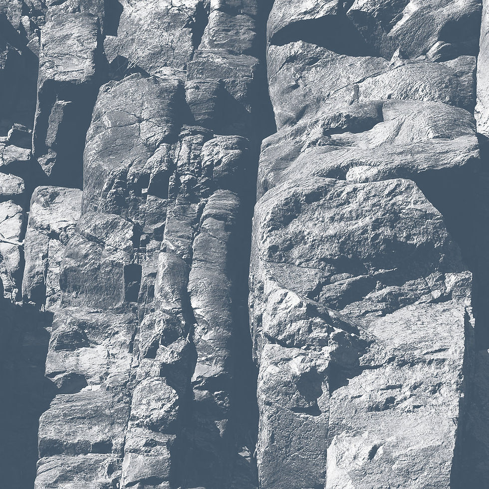 The cover for Australian musicians Nick Ashwood and Aviva Endean aka Driftwood's Maps album, showing a close-up of rough gray rock cliffs with layered, sunlit textures and deep crevices