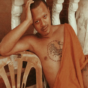 The cover for Hussain Bokhari's Possessions album on Mood Hut records, showing a man in a Buddhist monk style orange robe with a tattooed chest reclining on a plastic chair, hand resting on head. Background features white railings.