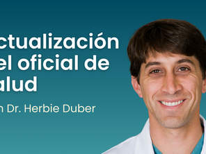 Un hombre de cabello oscuro con bata blanca sonríe a la cámara. El texto dice: Actualización del Oficial de Salud con el Dr. Herbie Duber.