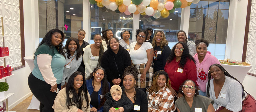 Un grupo de mujeres negras y un bebé sonriendo a la cámara.