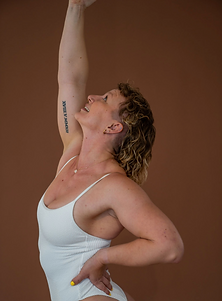 Coach Chloe in a grounded, graceful movement pose, showcasing embodied strength and minimal studio aesthetic for Coaching with Chloe email invite.