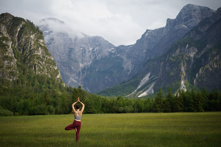 Frau macht Yoga im Freien, Yoga Grünau und Scharnstein, Berge im Hintergrund.
