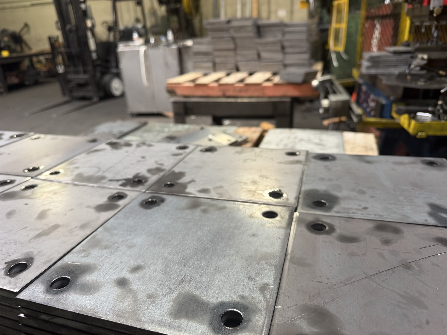 Steel plates with punched holes near their corners