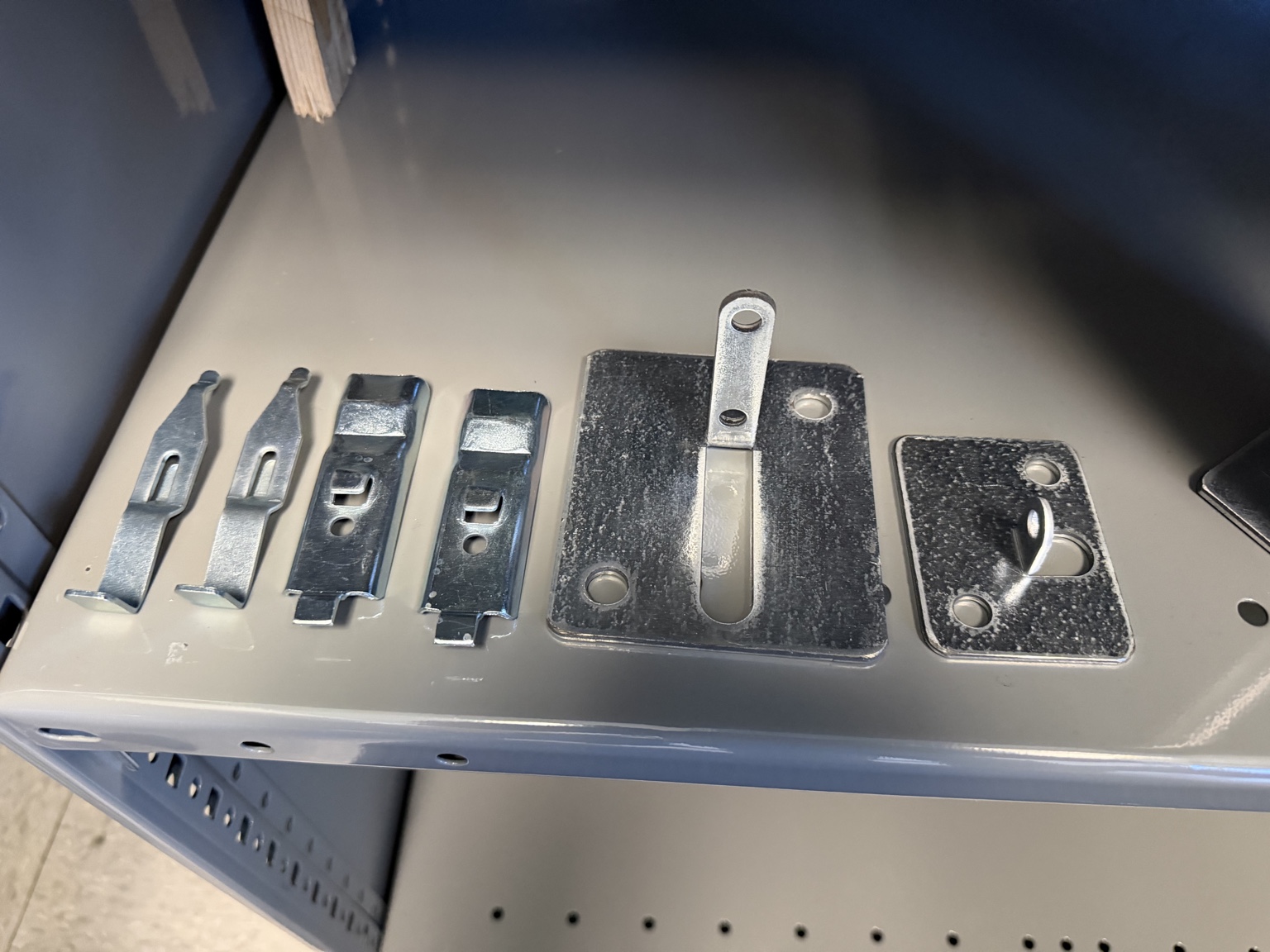 Selection of metal clips and plates with punched holes, slots, and formed tabs